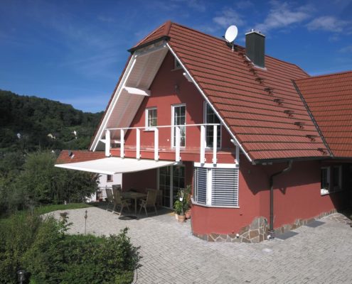 Markisen Hamburg - Großes Einfamilienhaus mit roter Fassade und weisser Markise